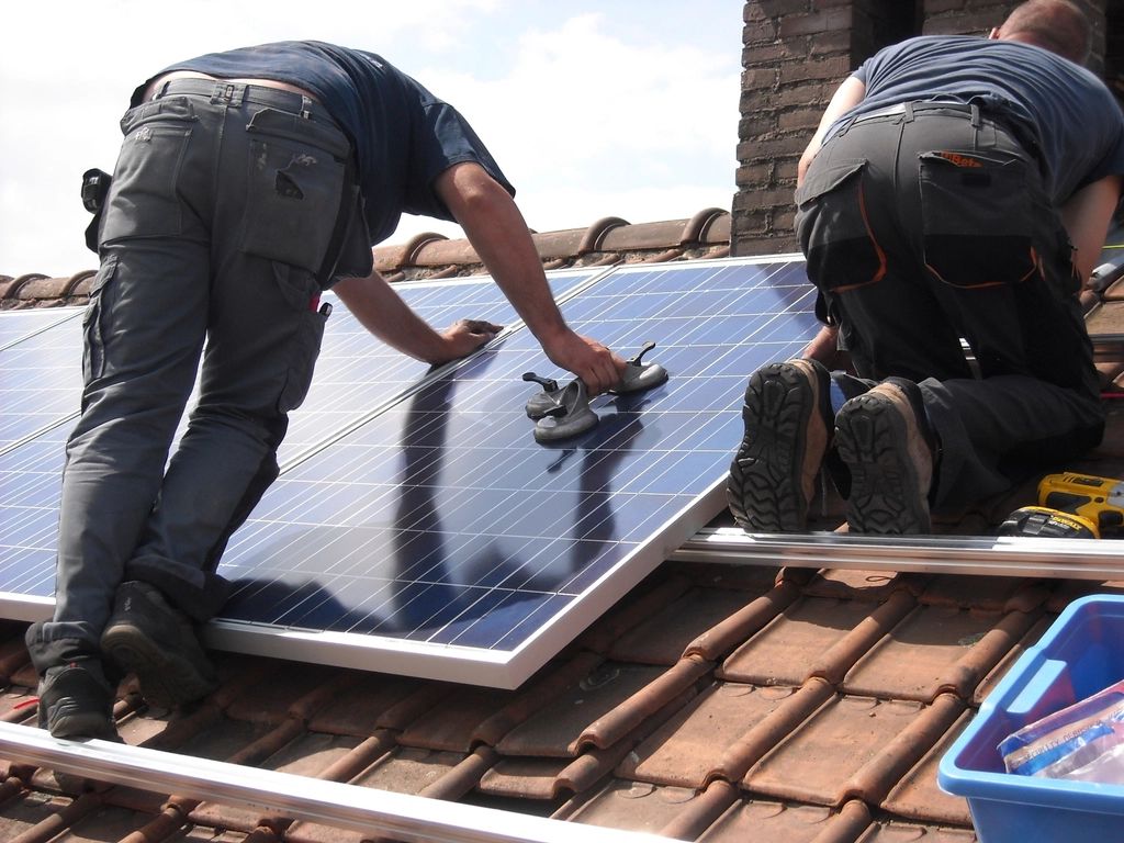 Installers fitting a solar panel